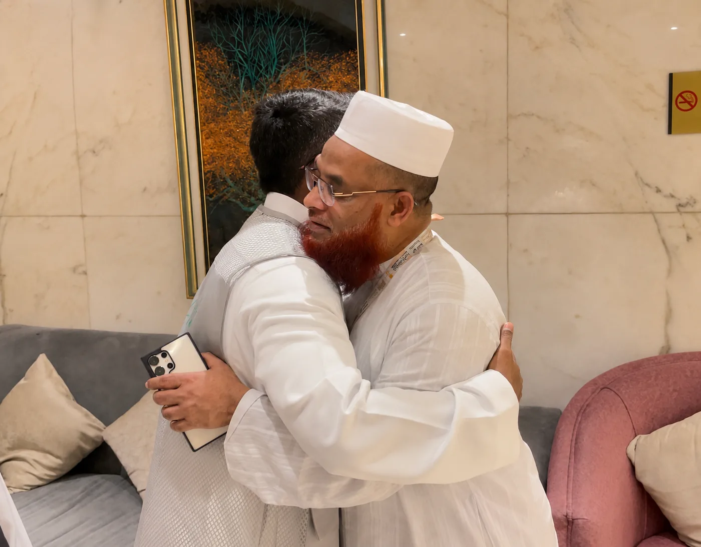 A Moeen team member warmly greeting a pilgrim at a hotel