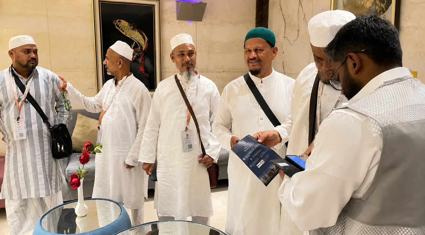 Moeen staff assisting a group of pilgrims inside their hotel