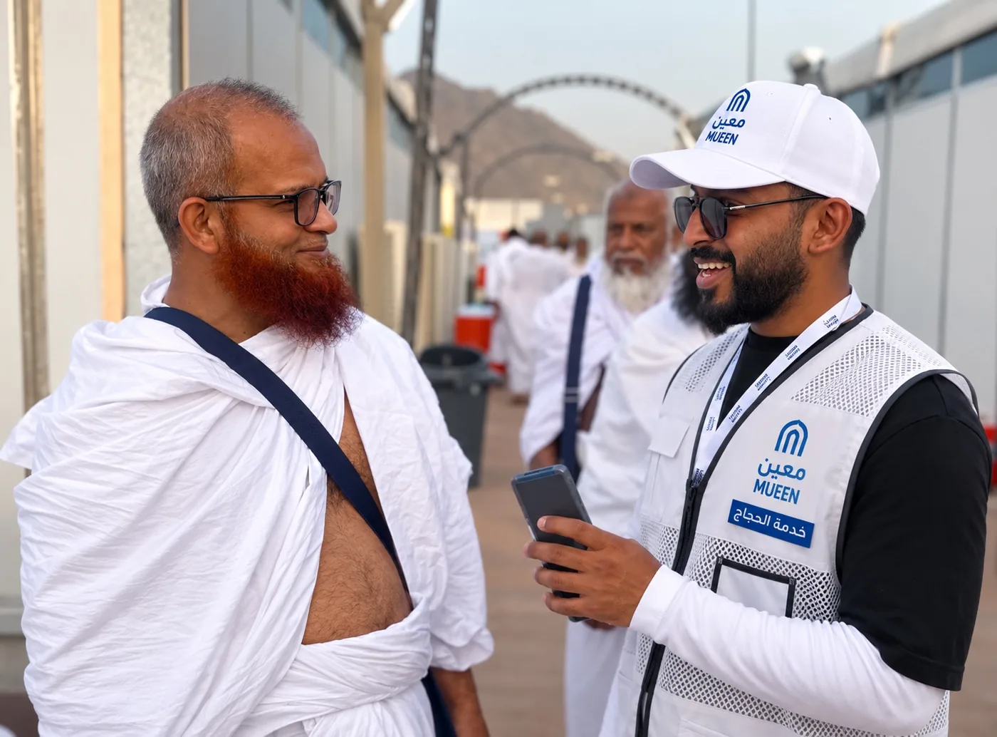 A Moeen field team member welcoming and speaking with a pilgrim